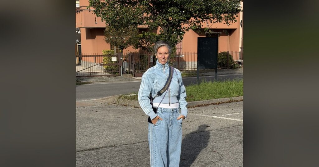 Federica Perini cammina in una strada residenziale, mani in tasca, sorridente