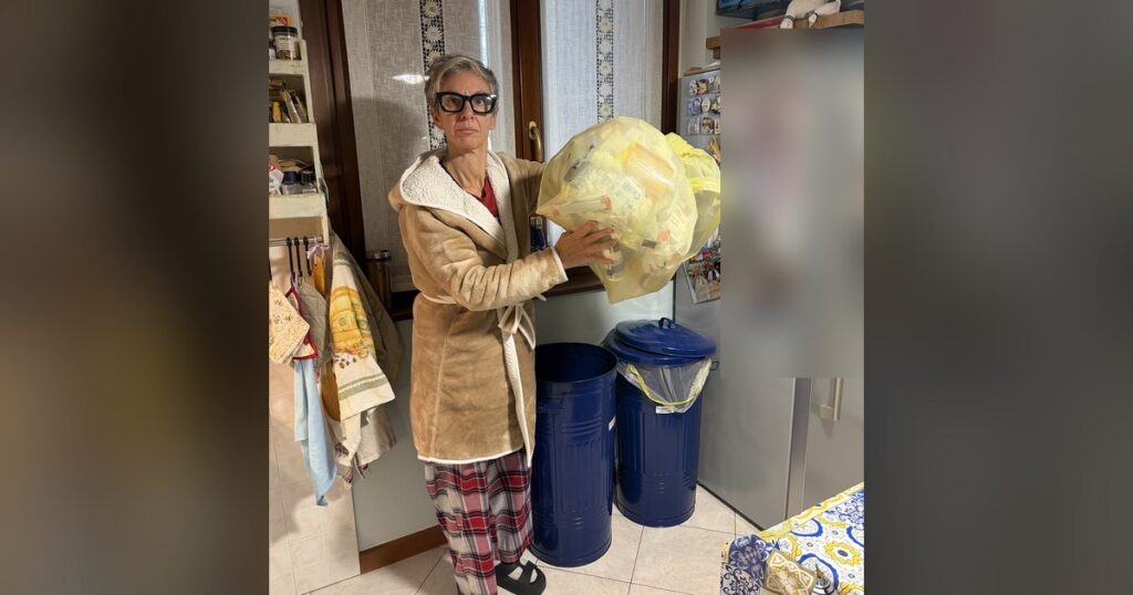 Federica Perini in cucina tiene in mano il sacco giallo della plastica